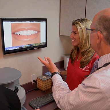 Dentist and patient looking at smile photos