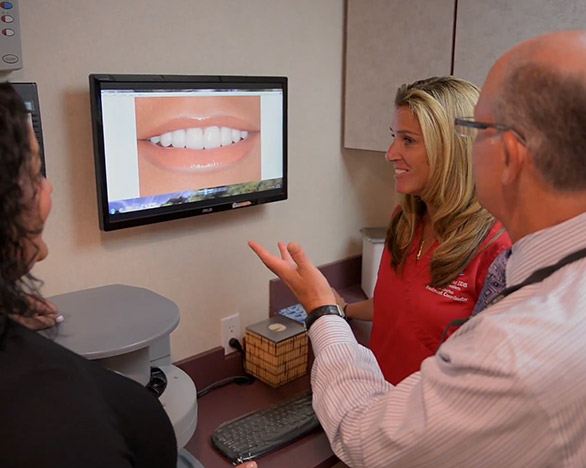 Dentist and patient looking at smile on computer in Massapequa Park cosmetic dental office