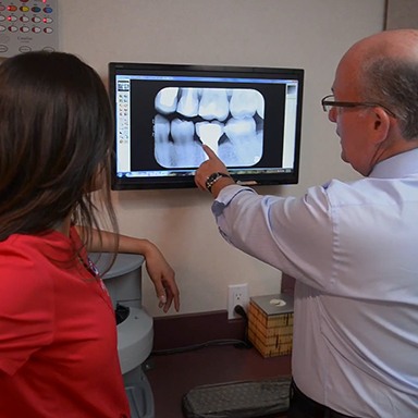 Dentist showing patient x-rays