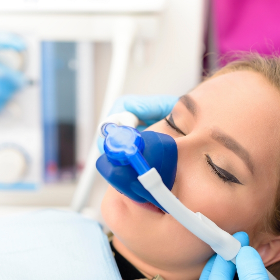 Woman in the dental chair with a nitrous oxide mask over her nose