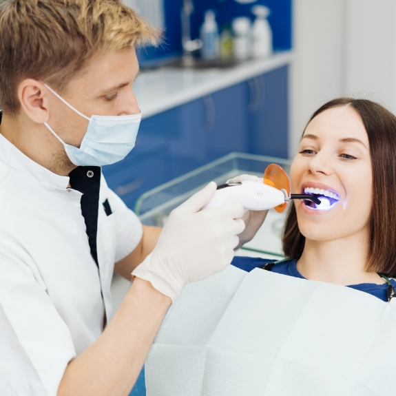 Dental patient having her mouth scanned with a focused beam of light