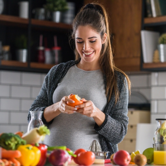Woman peeling fruit in her kitchen