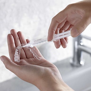 Hand holding a take home whitening tray