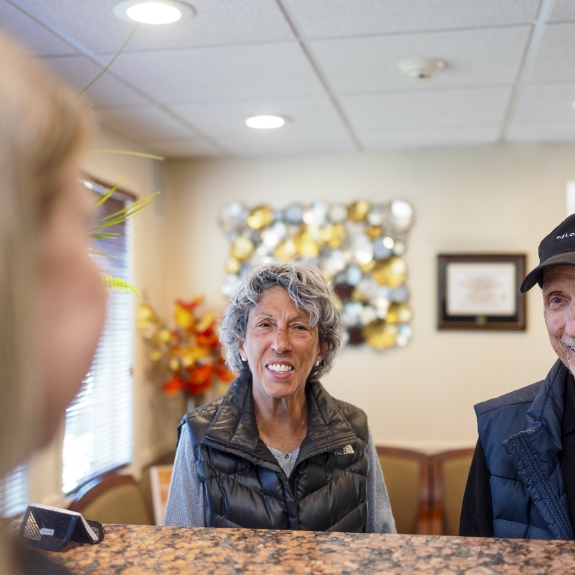 Senior couple checking in at dental office front desk