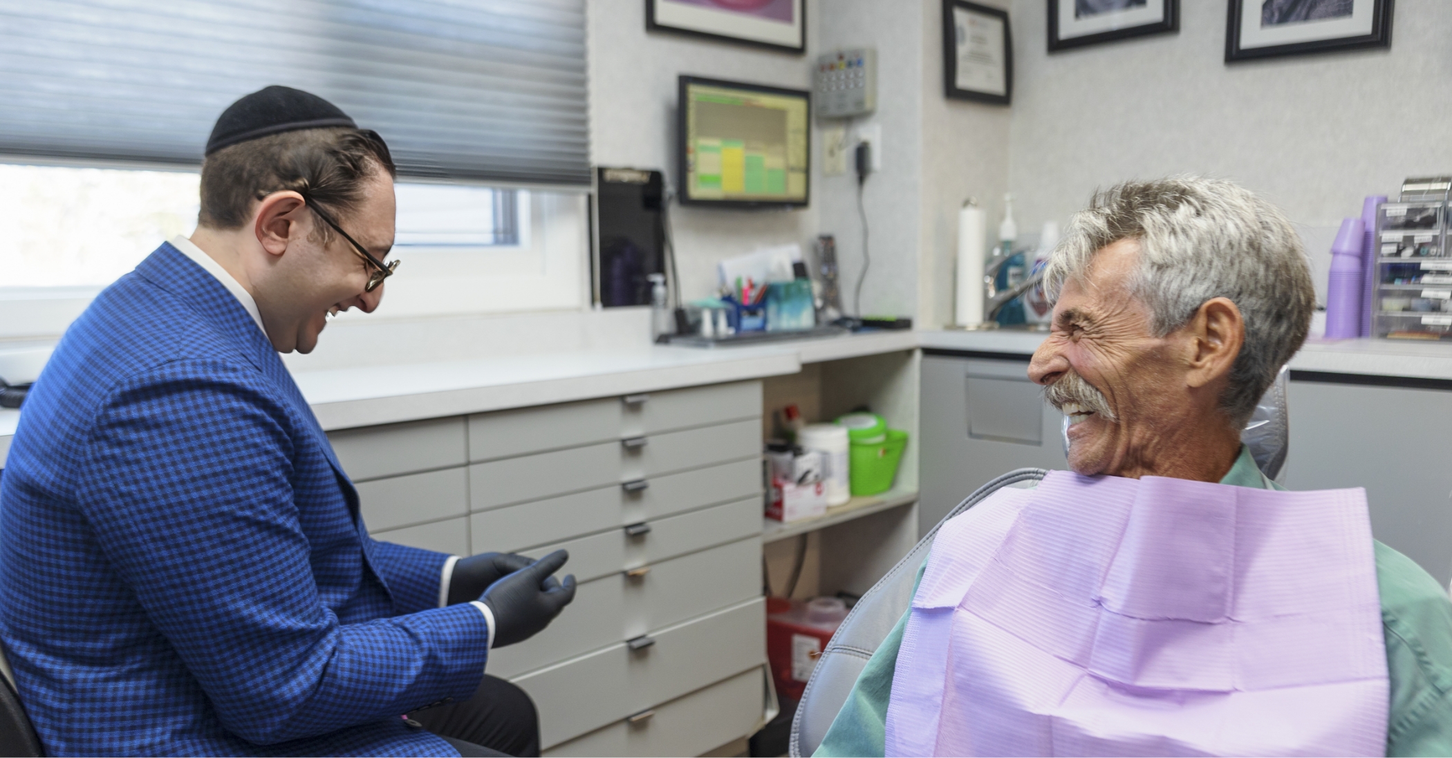 Doctor Ariel talking to a patient during a dental checkup in Massapequa Park