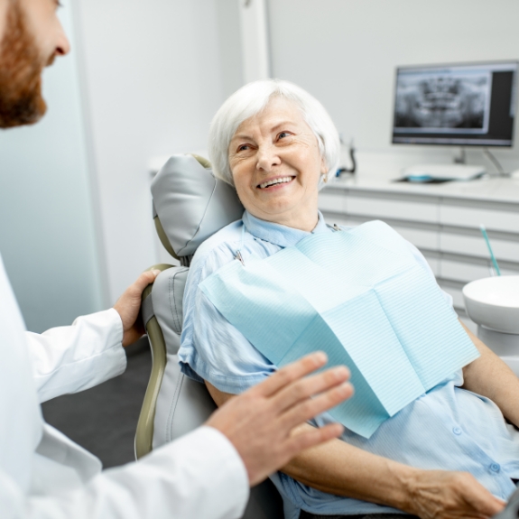 Senior woman in the dental chair smiling at her dentist