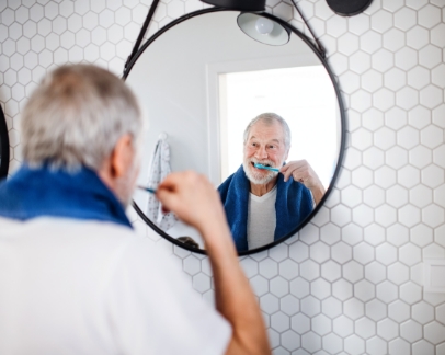 Senior man brushing his teeth at home