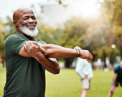 Man in exercise clothes stretching his arms at a park