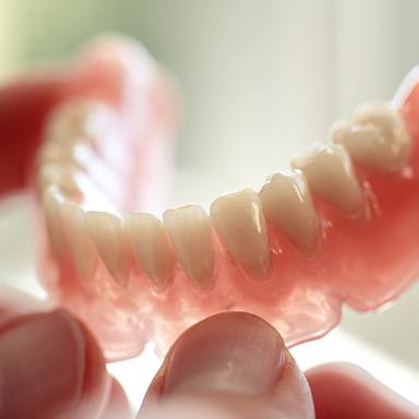 Man handling a partial denture on Long Island