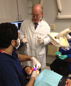 Dr. Mohr talking to student who is treating patient