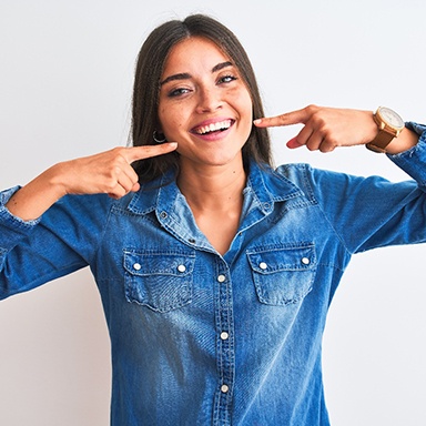 a patient pointing toward her smile