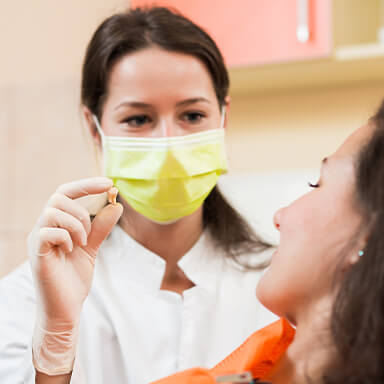Dentist showing patient an extracted tooth