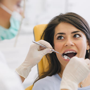 Female patient having her mouth examined by dentist