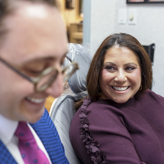 Woman in the dental chair smiling at Doctor Ariel