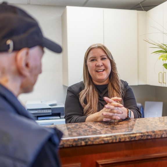 Man checking in at front desk of dental office