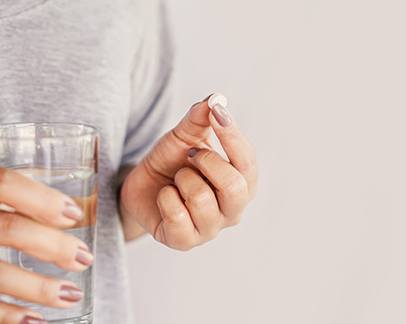 Woman taking pill after dental implant surgery