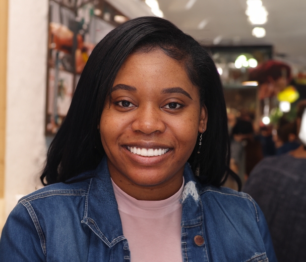 Woman in a denim jacket smiling with bright white teeth
