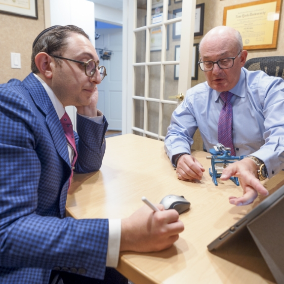 Doctor Mohr and Doctor Ariel having a discussion at a table in the dental office