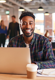 Smiling man behind laptop in Long Island