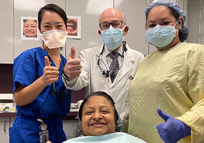 Dr. Mohr and dental team members giving thumbs up while standing next to patient