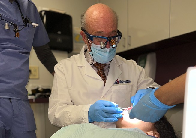 Dr. Mohr examining patient with magnifying glasses