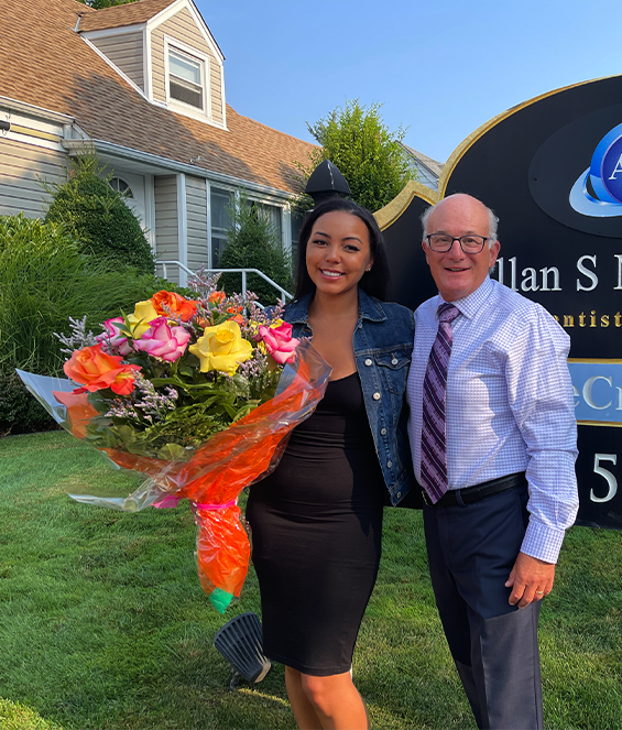Crystal smiling with flowers and Dr. Allan Mohr after best veneers and porcelain crowns