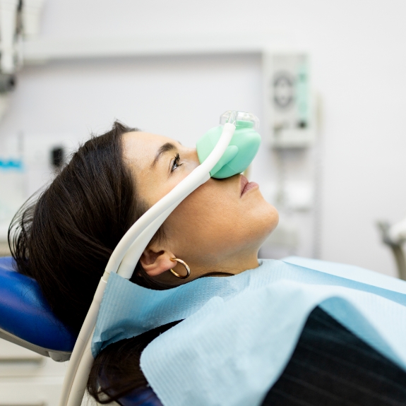 Woman in the dental chair with a nitrous oxide mask over her nose