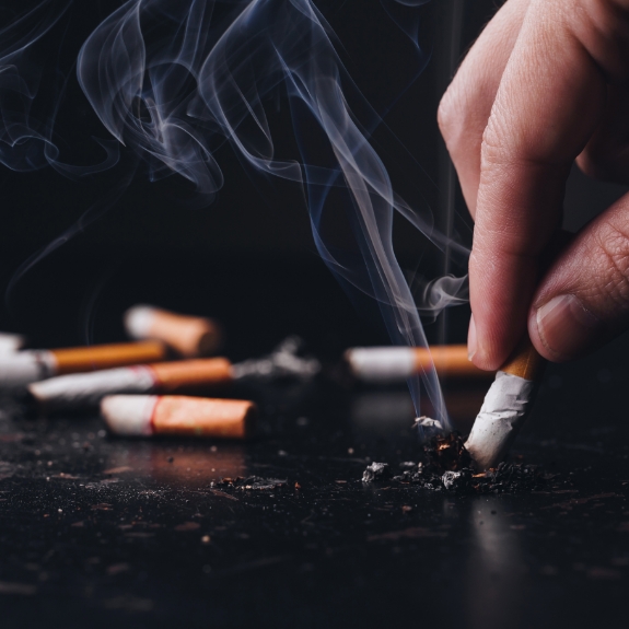 Close up of a hand ashing a cigarette