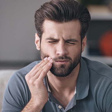 Man holding jaw in pain