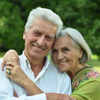 Smiling couple with Long Island implant dentist, Dr. Allan Mohr