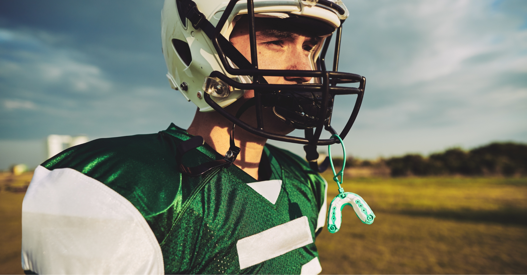 Football player with an athletic mouthguard attached to their helmet