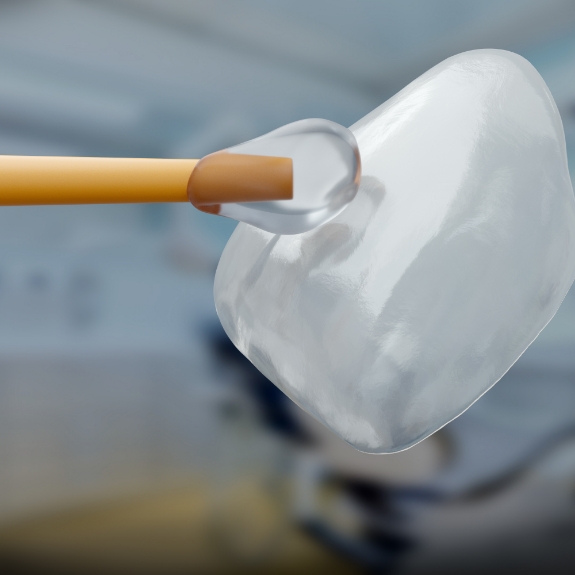 Close up of adhesive gel being applied to one side of a veneer