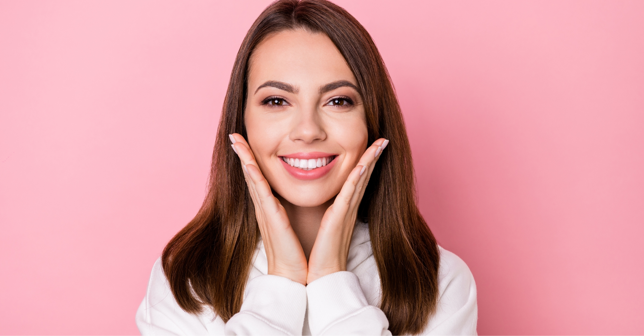 Smiling woman framing her face with her hands after Zoom teeth whitening in Massapequa Park