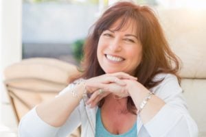 middle aged woman smiling on couch