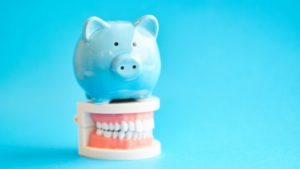 piggy bank on top of model teeth