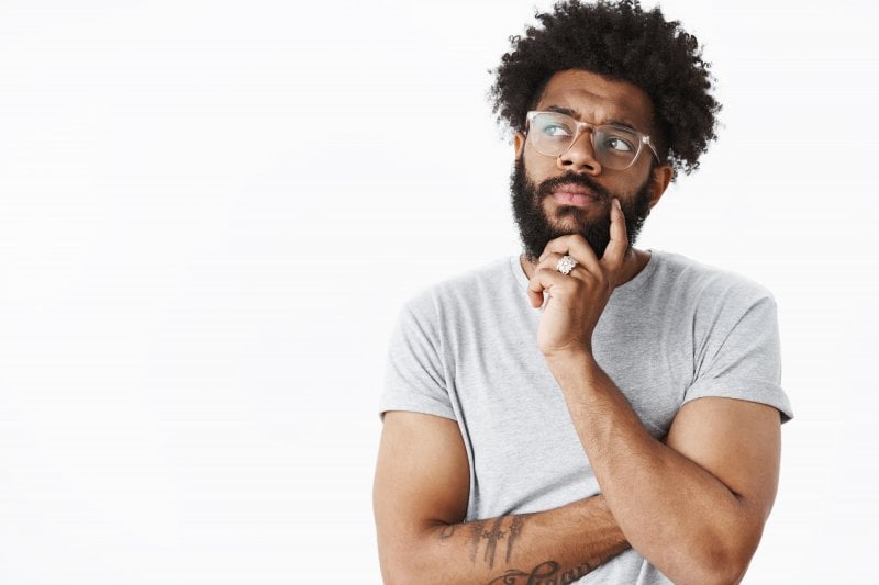 young man thinking about bridges and dentures