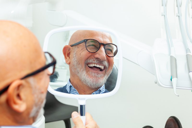 older male patient smiling about dental implant