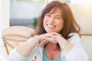 middle aged woman smiling on couch 