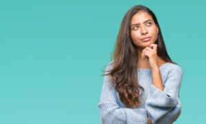 young woman thinking about cosmetic bonding and veneers 