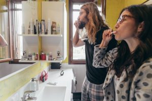 young couple brushing teeth at home