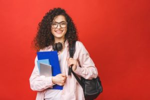 female high schooler with bag and headphones