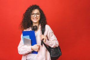 female high schooler with bag and headphones 