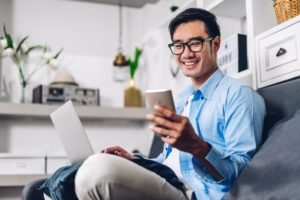 young man looking at phone while smiling 