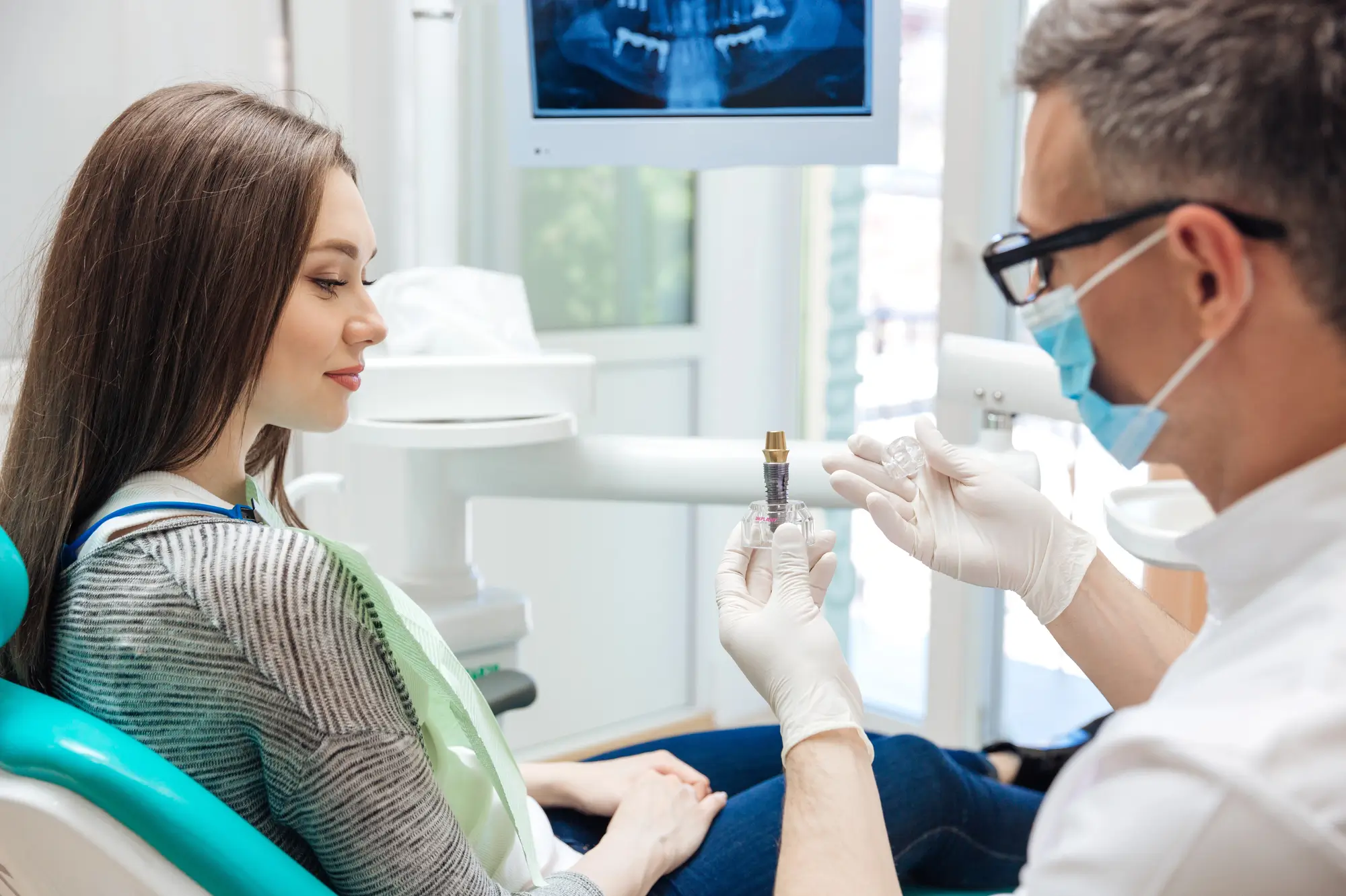 Dentist in Massapequa explaining dental crowns to a female patient