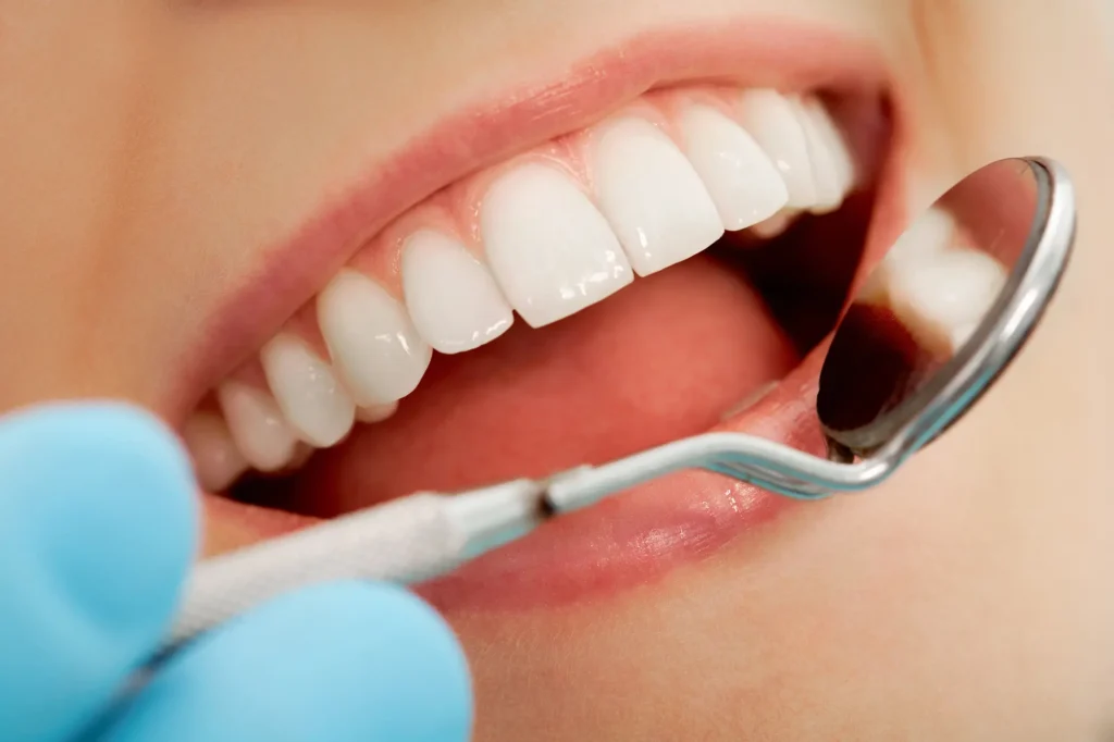 Dentist performing mouth checkup for full mouth reconstruction Long Island