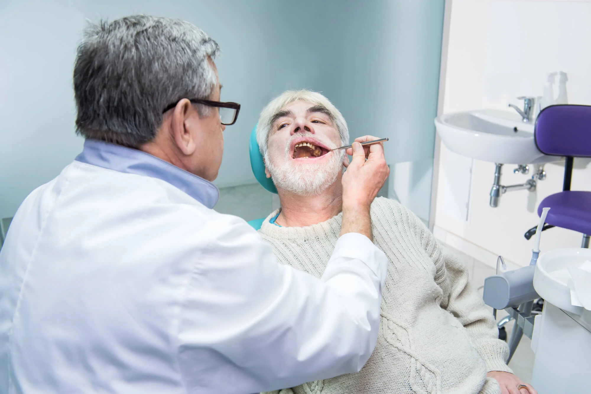 Long-Island-dentist-checking-senior-patient