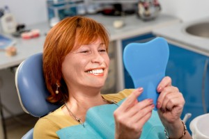 smiling woman with beautiful teeth thanks to the dental implants bellmore residents trust